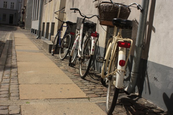 Bikes parked along the sidewalk in Copenhagen, Denmark